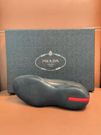 Prada leather lace-up shoes in dark blue, close view of textured sole and red heel tab