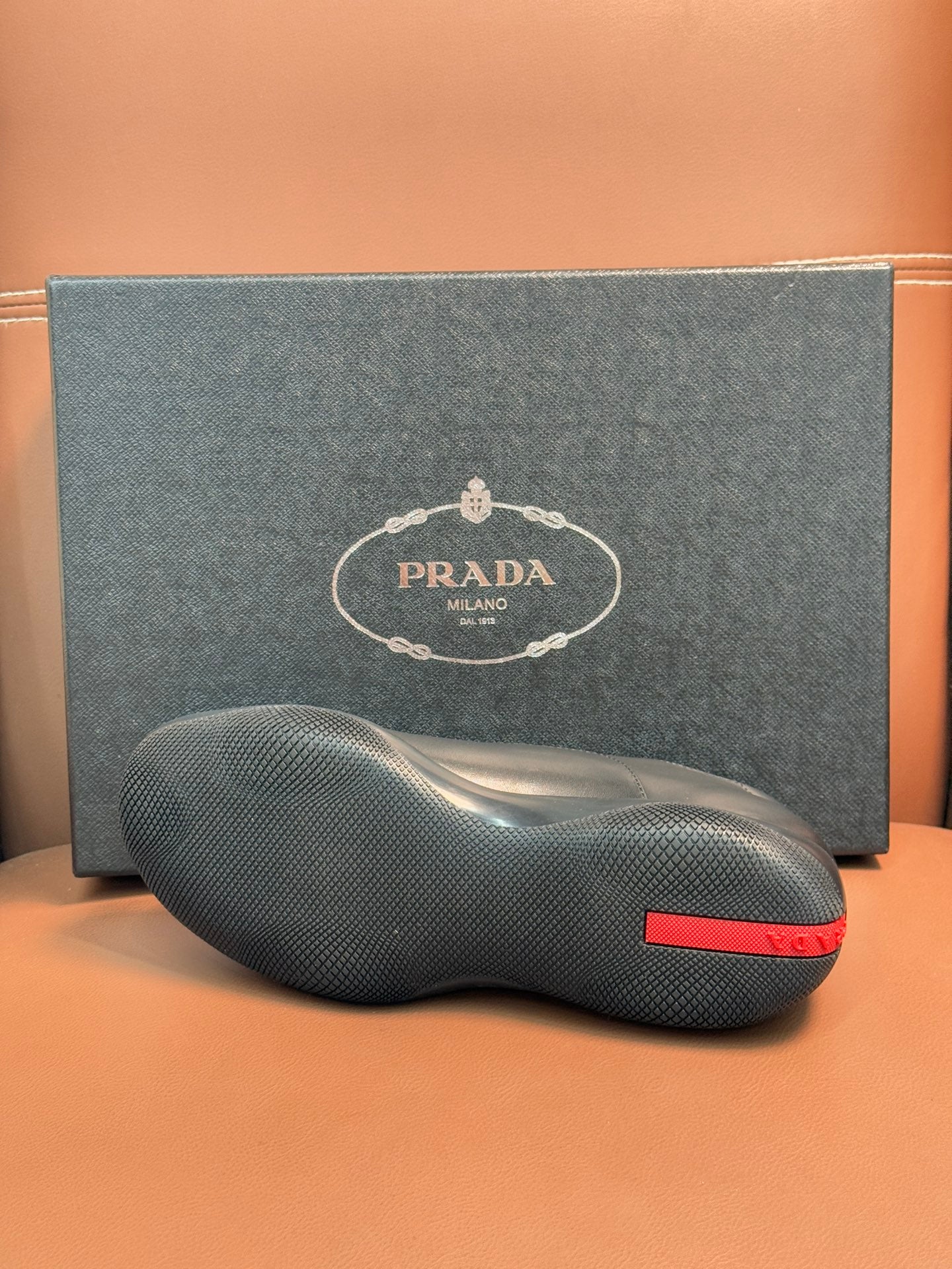 Prada leather lace-up shoes in dark blue, close view of textured sole and red heel tab