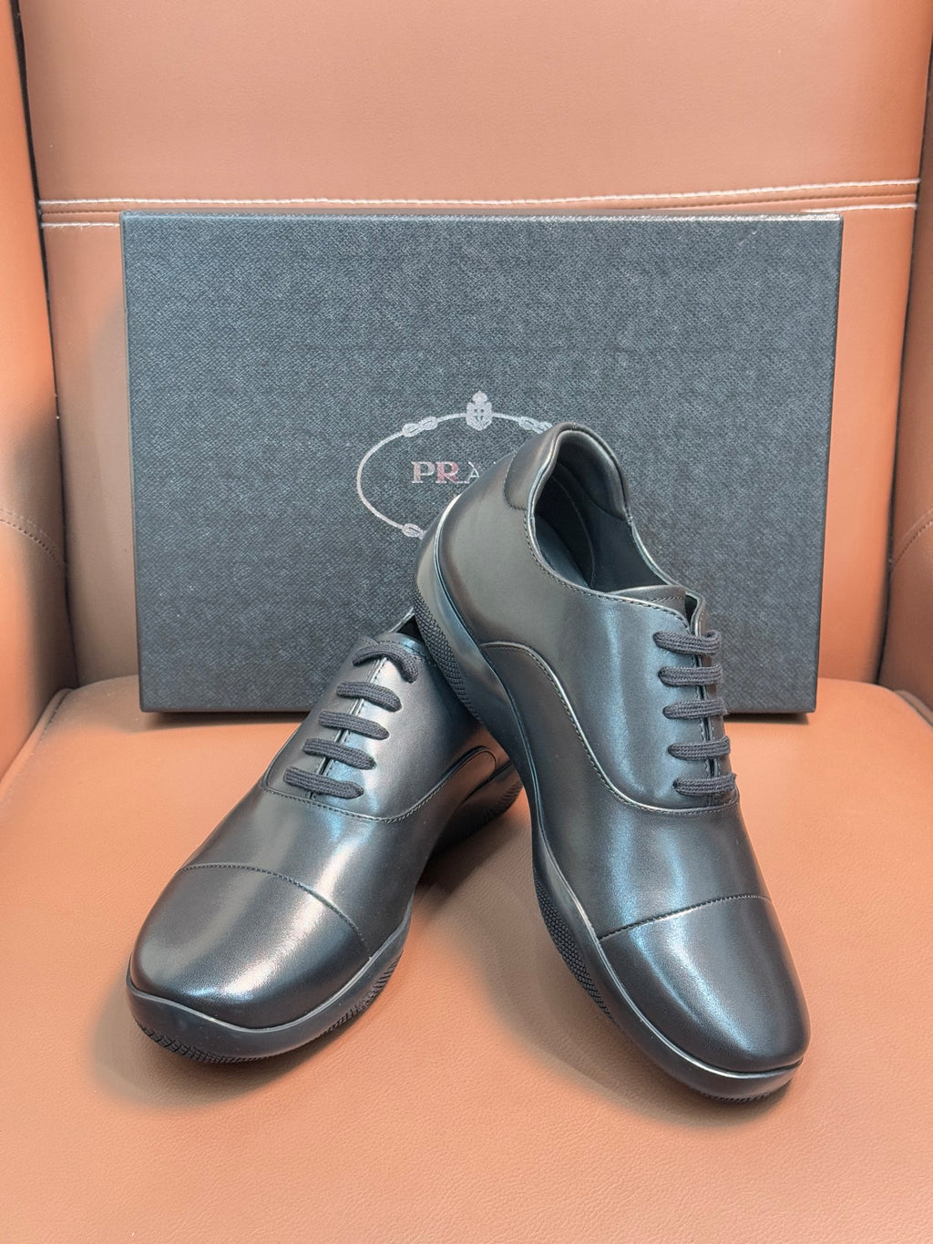 Prada lace-up leather shoes in dark blue, close view of laces and smooth uppers