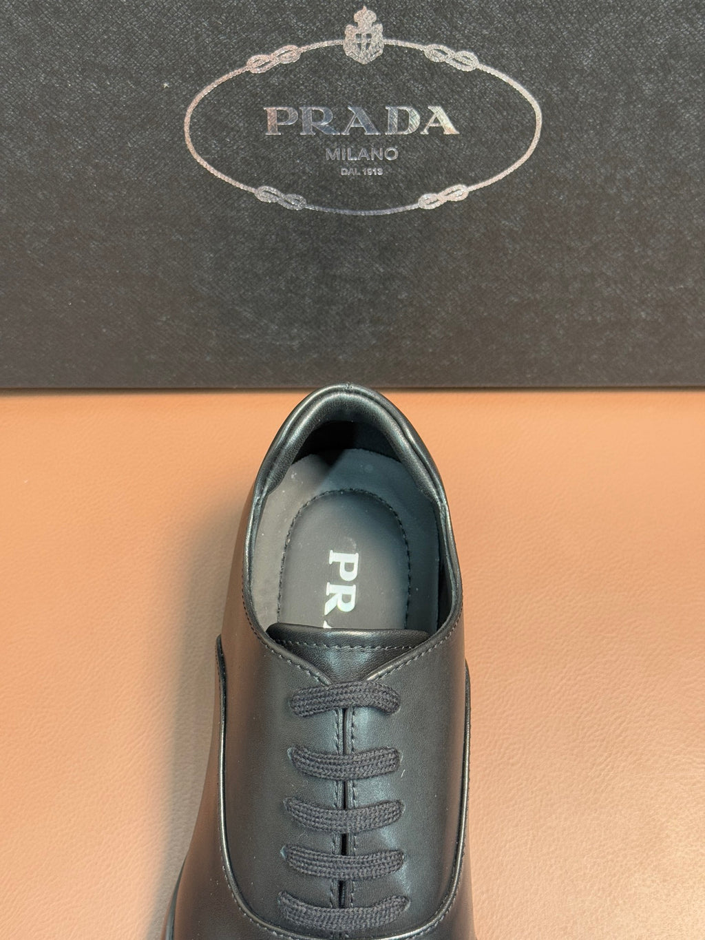 Prada lace-up leather shoes in dark blue, close view of toe and lace panel