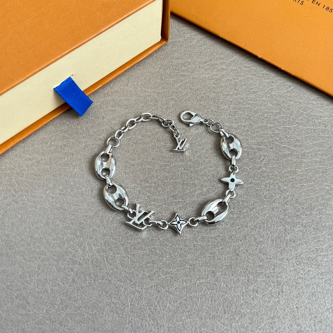 Silver charm bracelet with oval links and star, clover, and LV charm details