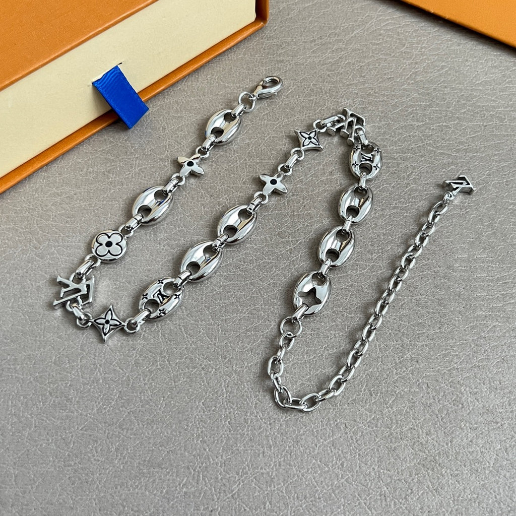 Silver-tone charm bracelet with clover, star and flower motifs, adjustable chain