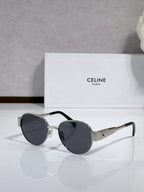 Round sunglasses with dark frame and tinted lenses, gold-tone hinges, slim metal arms