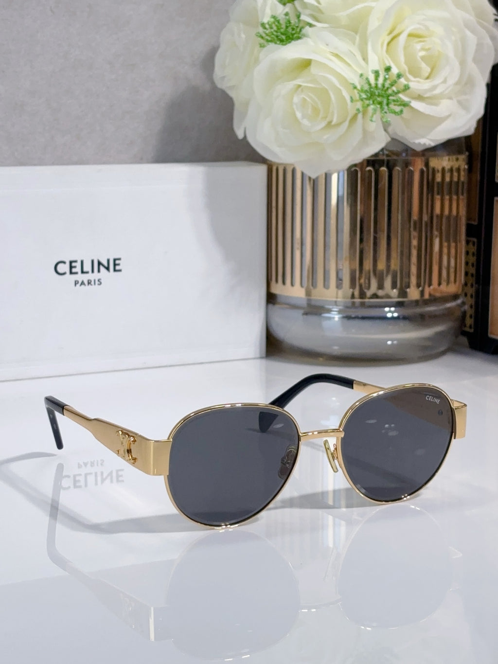 Round sunglasses with dark lenses and gold-tone bridge, tortoise temple tips