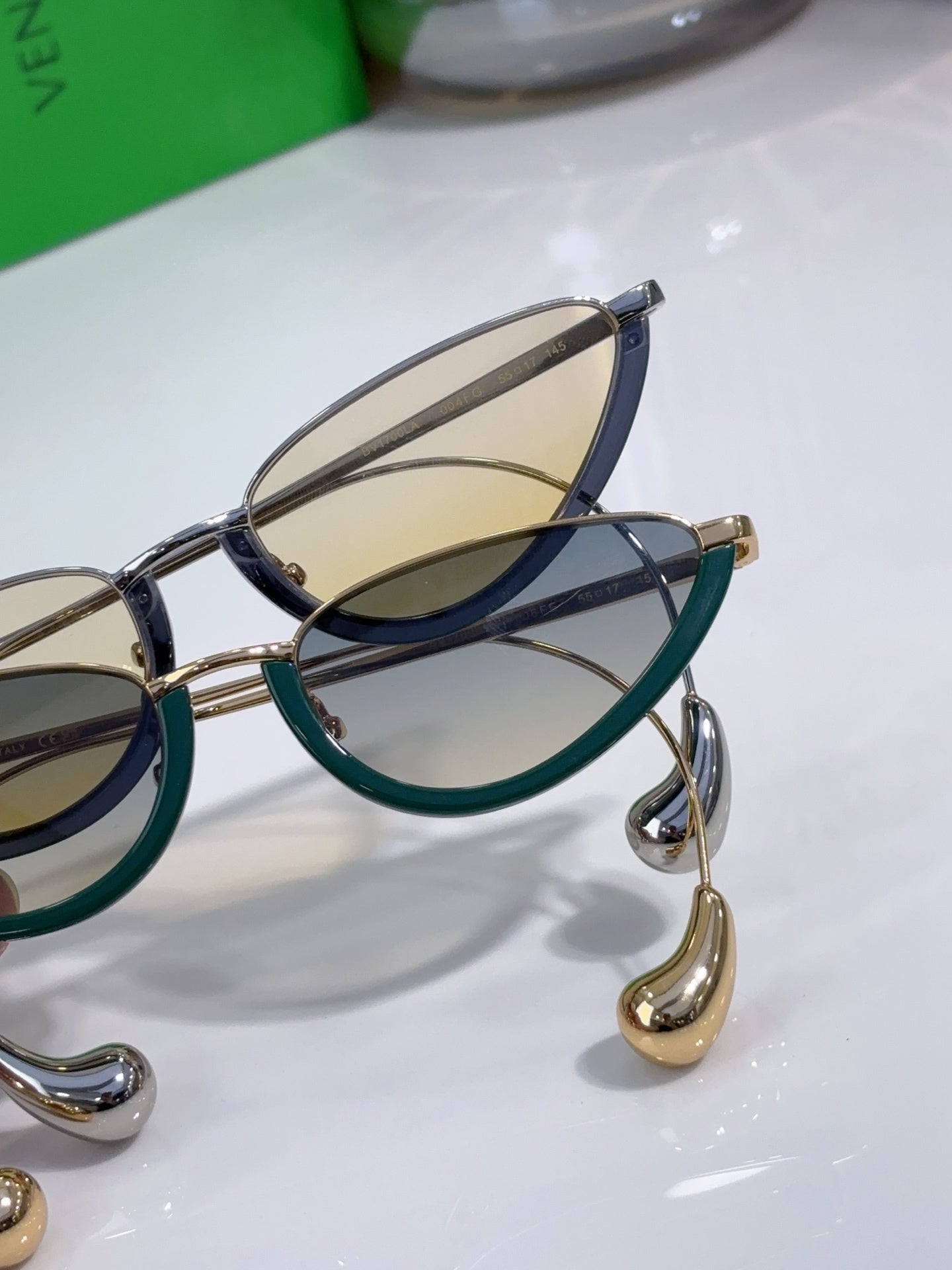 Cat-eye glasses with dark blue frame, green inlay, and amber lenses