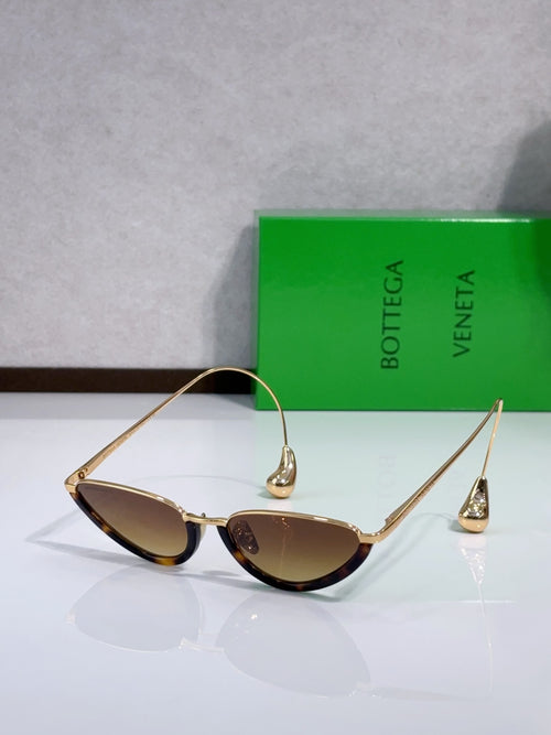 Cat-eye sunglasses with thin gold frame and amber lenses, side angle