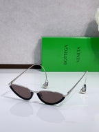 Cat-eye sunglasses with silver-toned frame and dark lenses, front angle