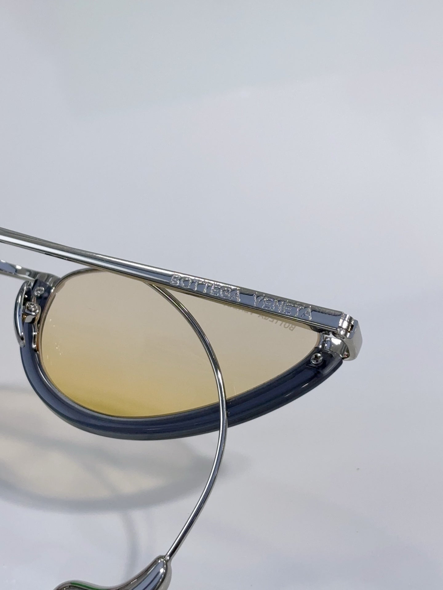Cat-eye glasses with blue frame and gold-tinted lenses, embossed temple