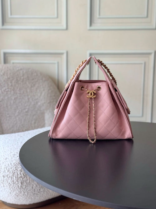 Pink quilted Chanel bucket bag with gold chain strap and top opening