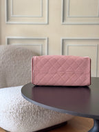 Pink Chanel quilted handbag with flap top and metal clasp on rear