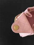 Pink Chanel handbag corner with round gold snap button and quilted leather panel