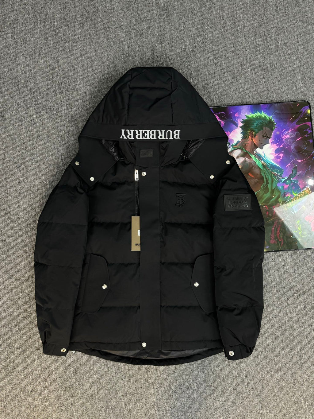 Black hooded puffer jacket with Burberry logo on the hood