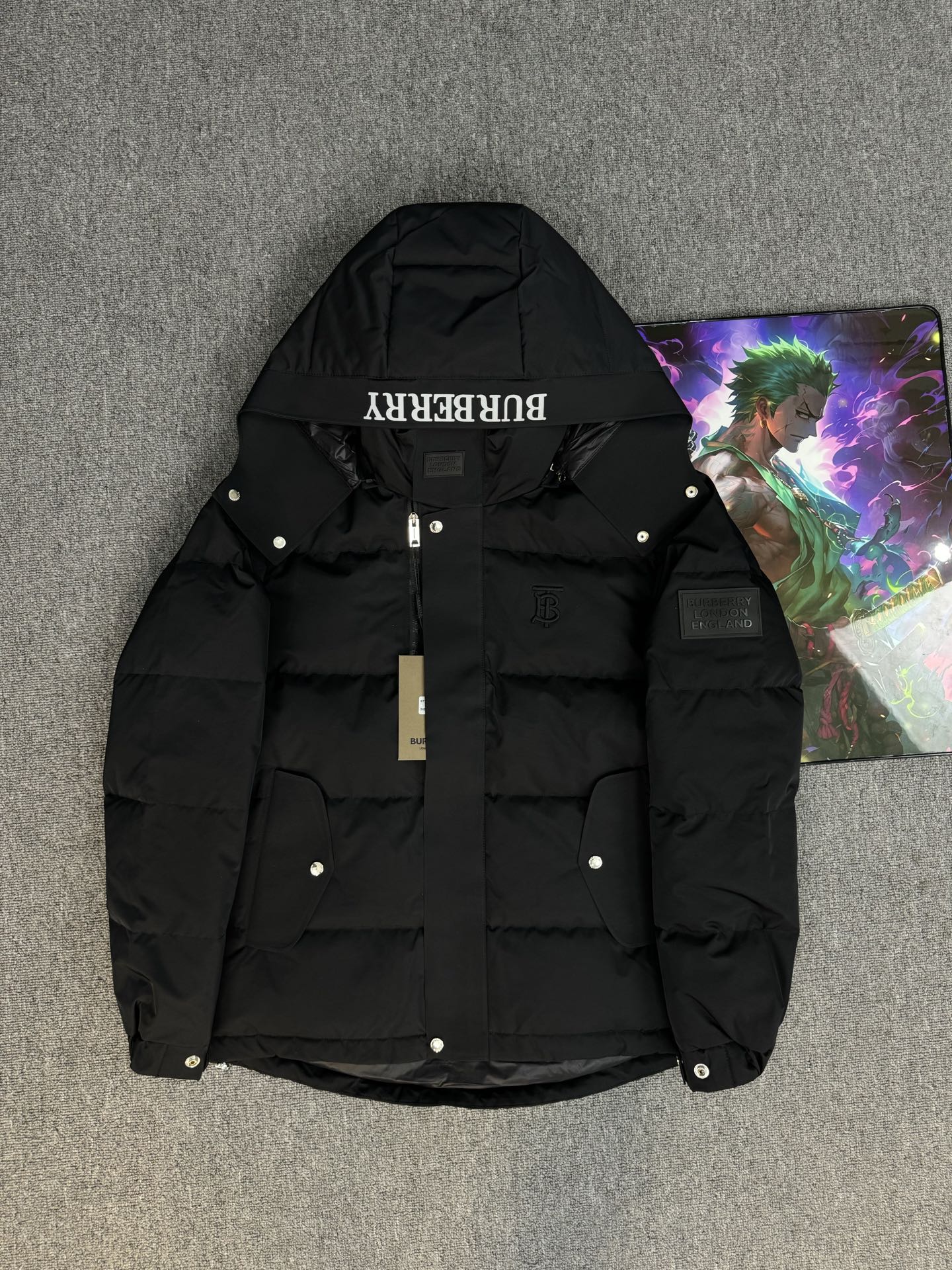 Black hooded puffer jacket with Burberry logo on the hood