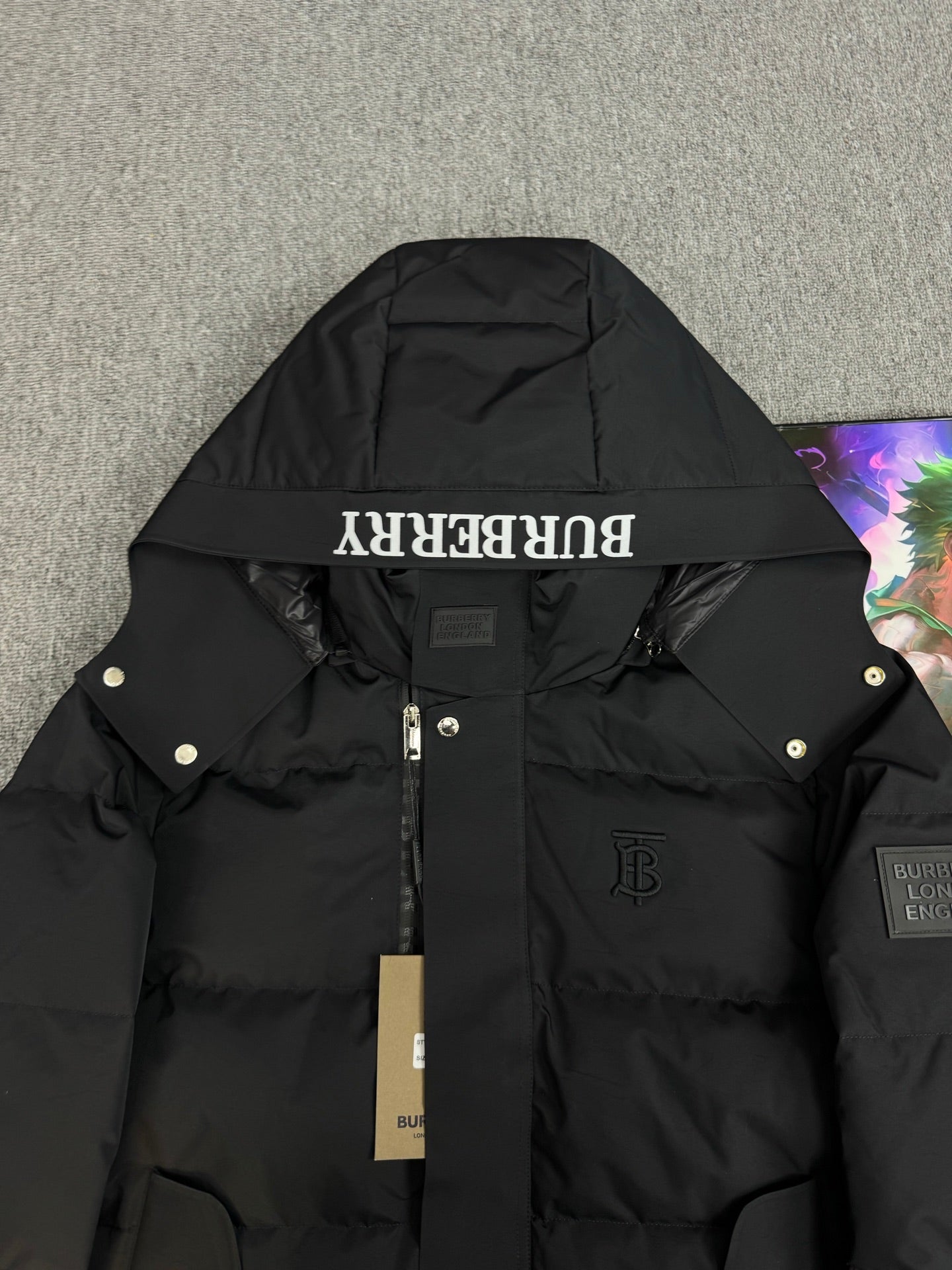 Black hooded puffer jacket with Burberry logo detail on hood panel