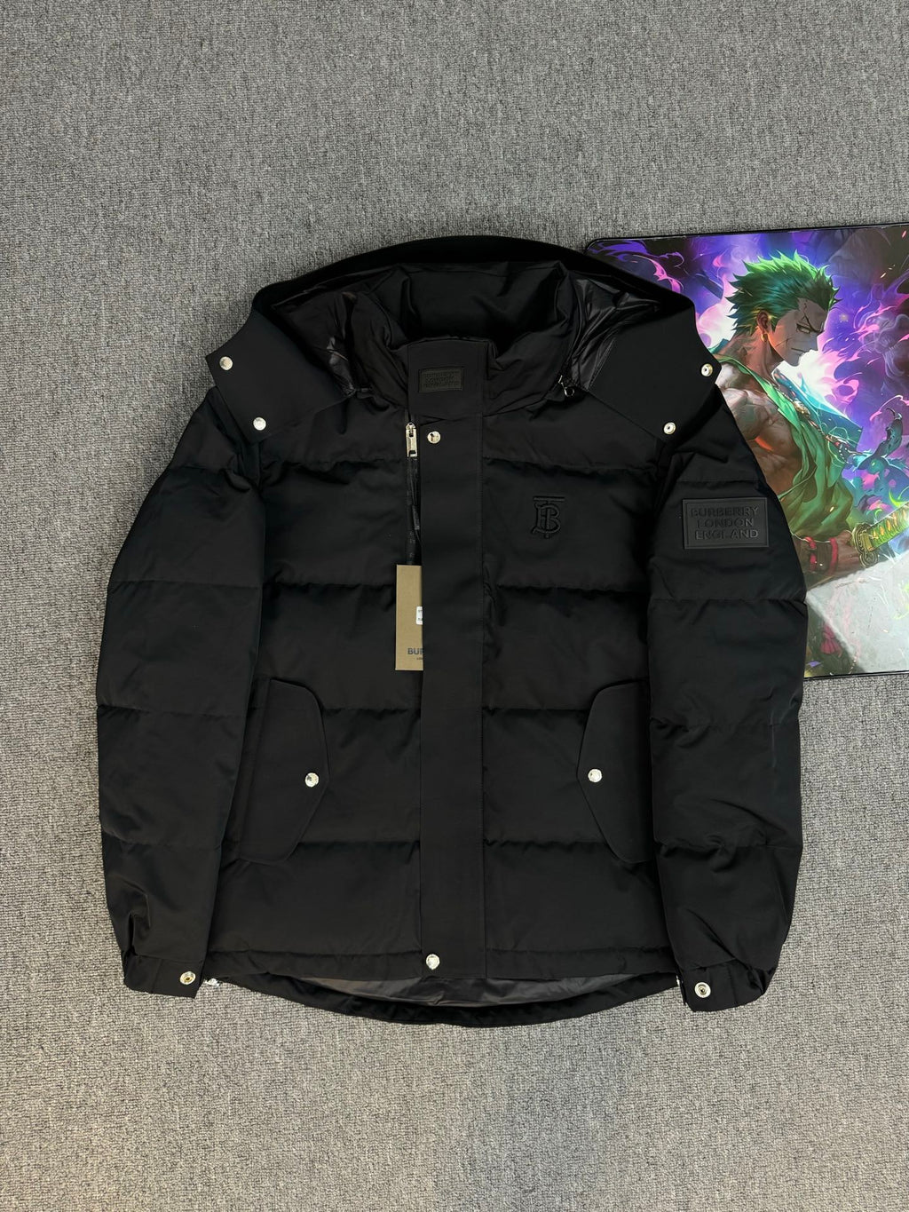 Black hooded puffer jacket with zip front and snap buttons