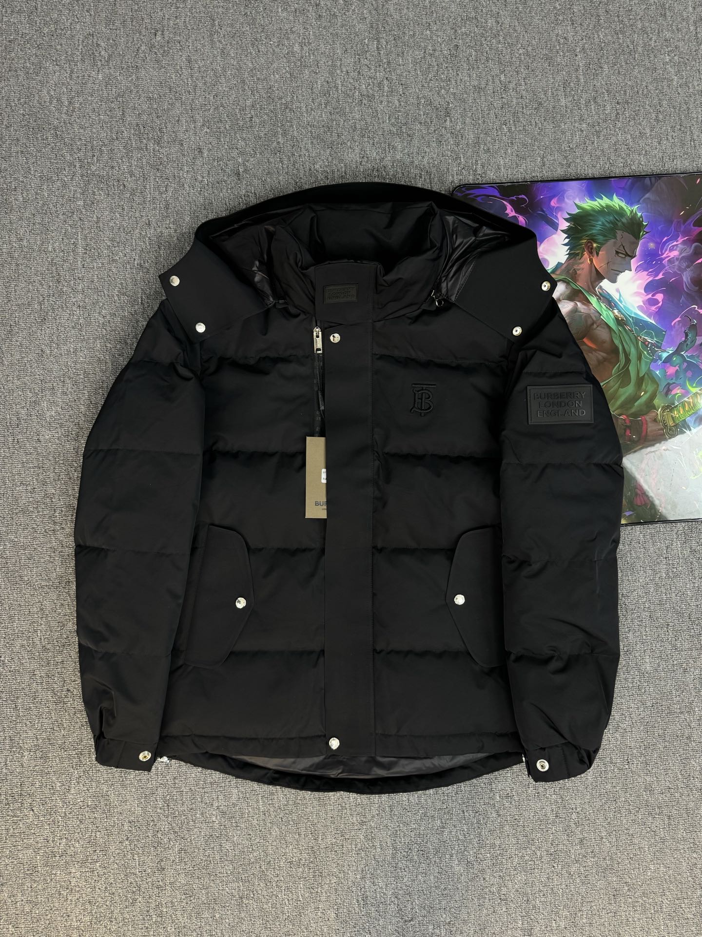 Black hooded puffer jacket with zip front and snap buttons