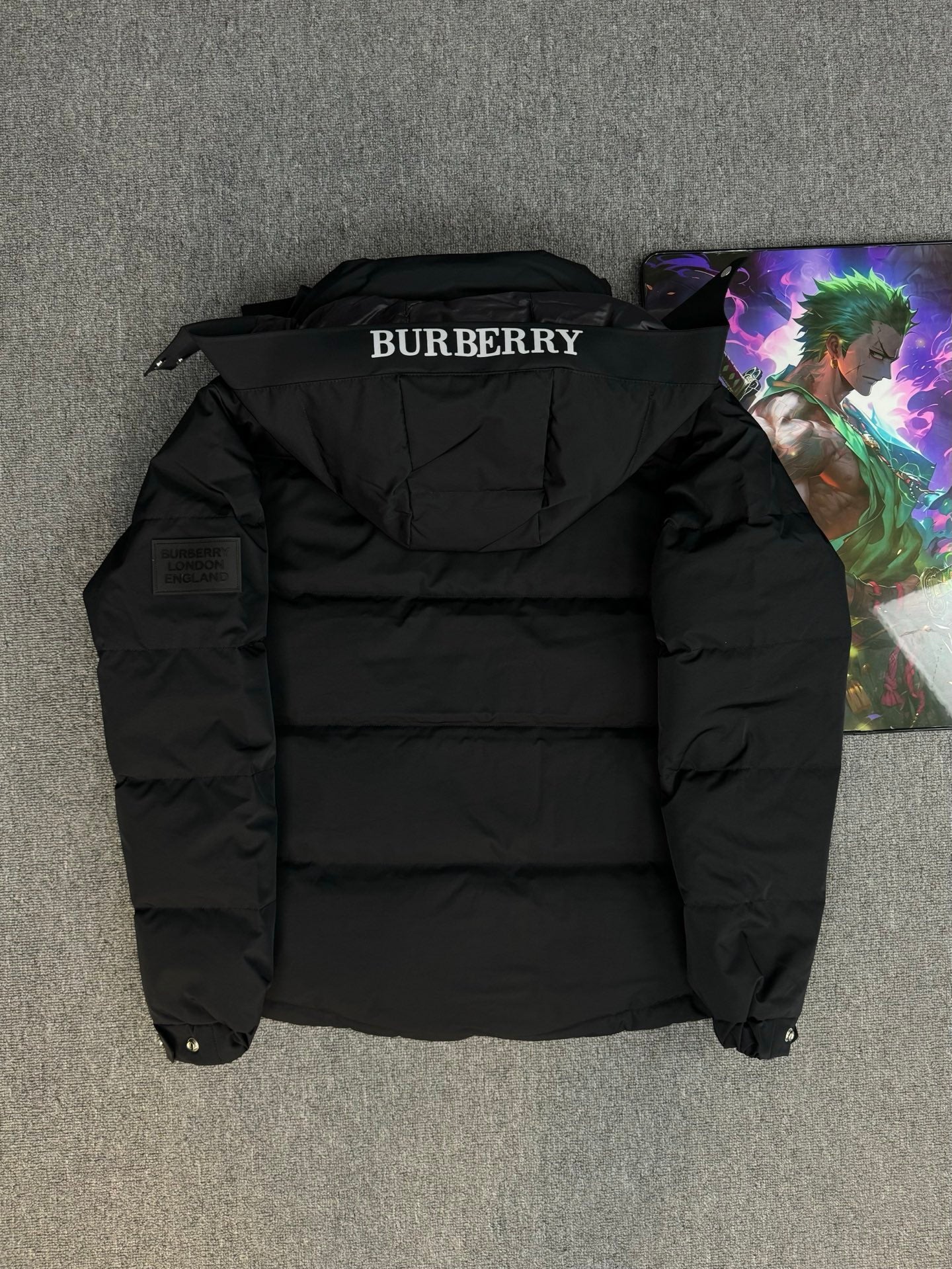 Black hooded puffer jacket back view with BURBERRY logo on collar