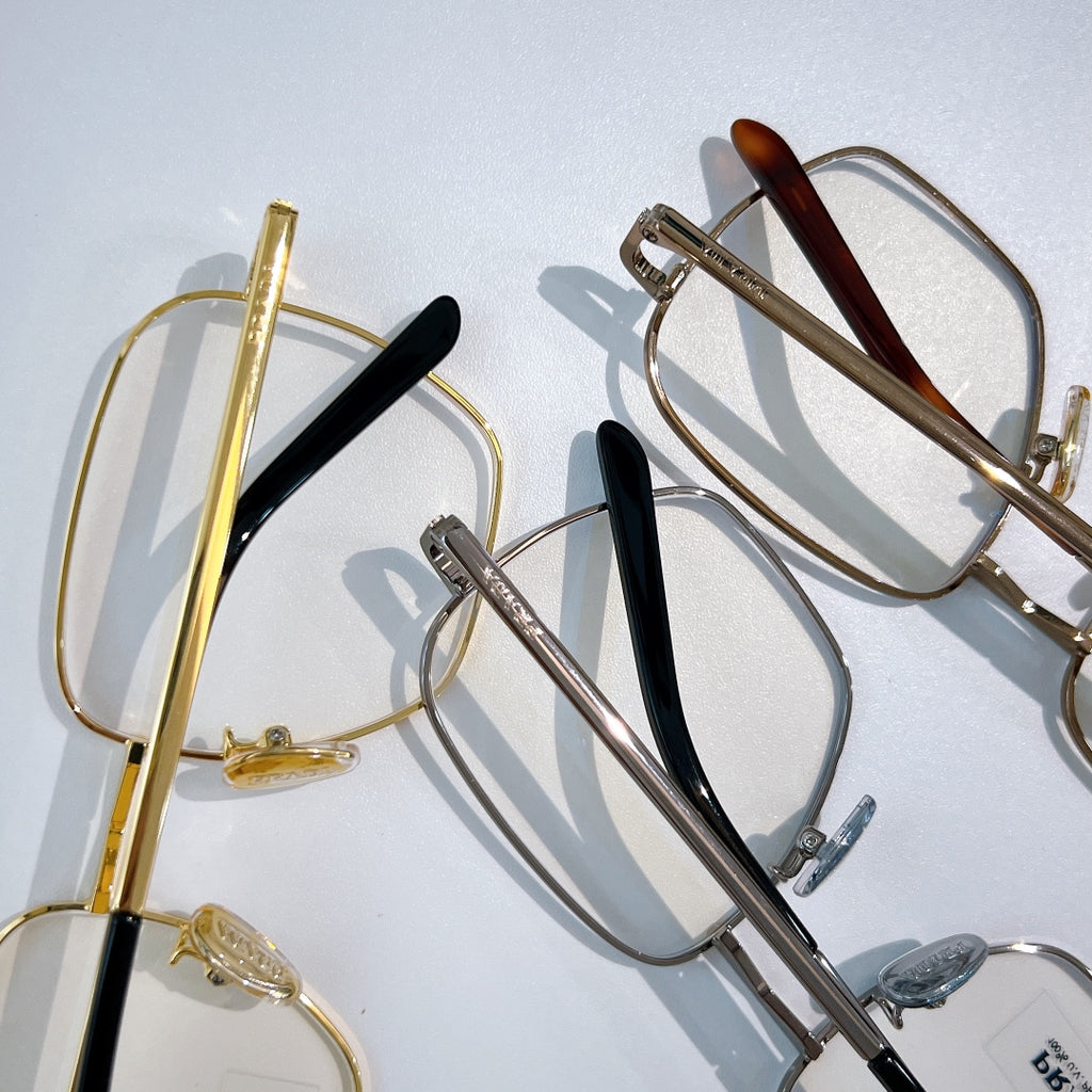 Assorted eyeglasses with metal frames, gold and silver tones, dark temple details.