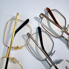Assorted eyeglasses with metal frames, gold and silver tones, dark temple details.