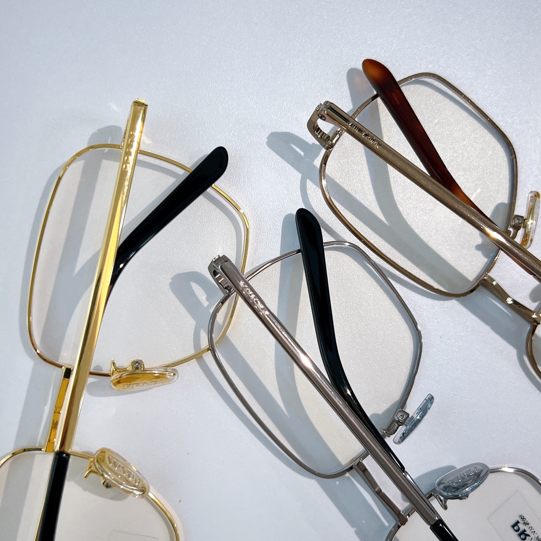 Assorted eyeglasses with metal frames, gold and silver tones, dark temple details.