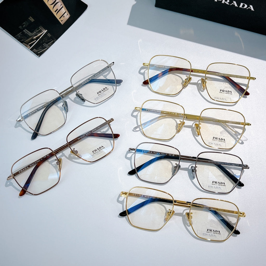 Assorted Prada eyeglasses with clear lenses and mixed metal frames arranged on display.