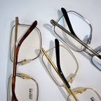 Prada eyeglasses with mixed frames: red, black, and gold metal, clear lenses