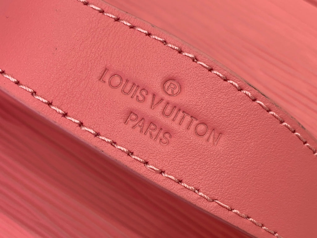 Louis Vuitton pink leather tag with embossed logo and Paris text, stitched edge.