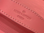 Louis Vuitton pink leather tag with embossed logo and Paris text, stitched edge.