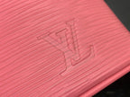 Louis Vuitton pink Epi leather close-up with embossed LV initials.