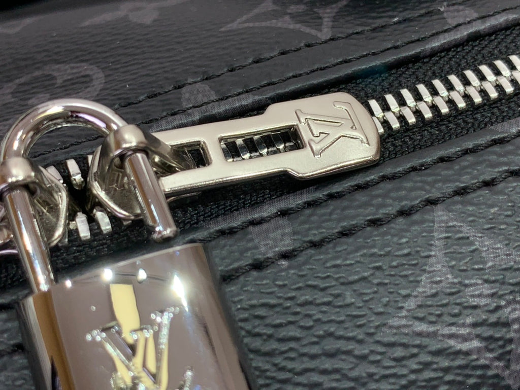 Louis Vuitton monogram handbag zipper pull with metal hardware, close-up.