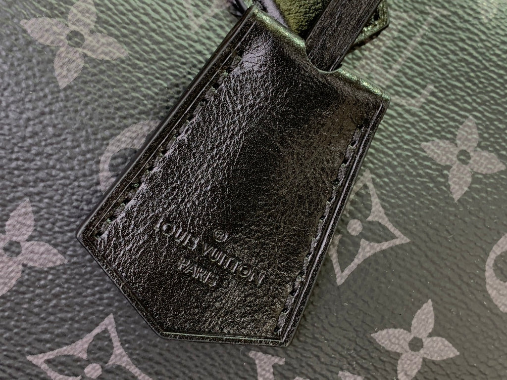 Louis Vuitton monogram handbag leather patch with dangling strap loop, close-up.