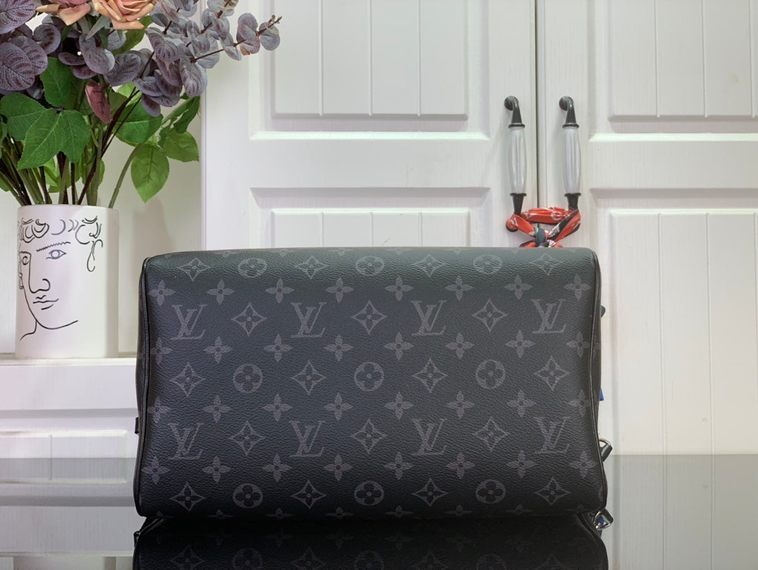 Louis Vuitton monogram handbag with structured body and dark leather trim, back view.