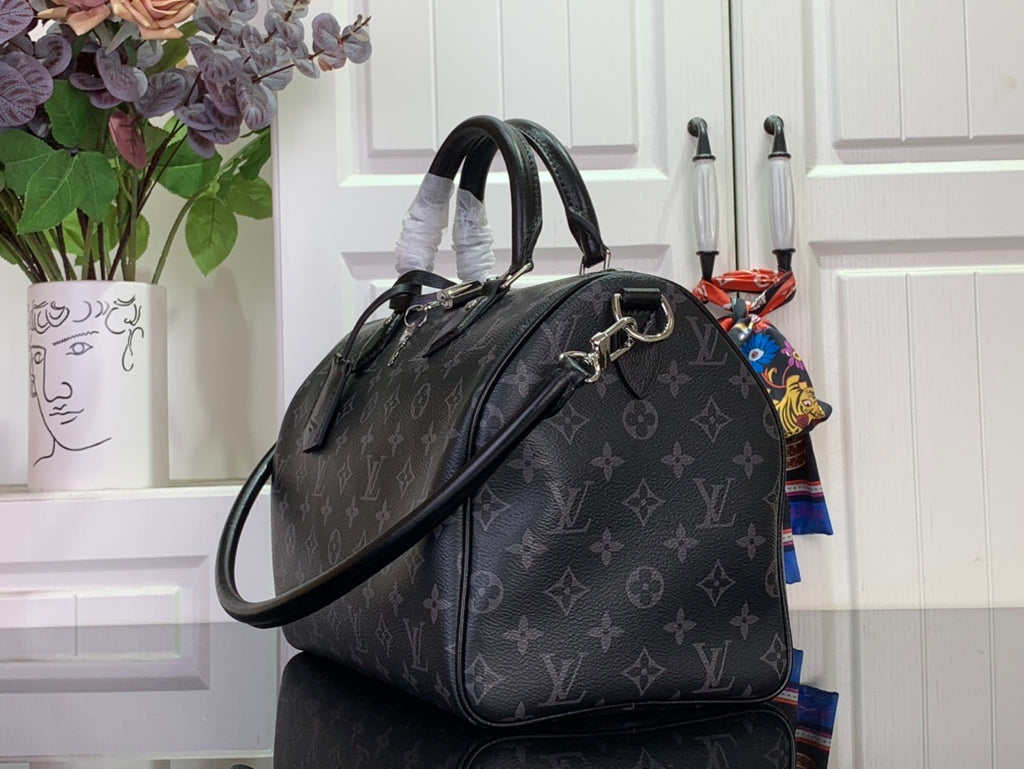 Louis Vuitton monogram handbag with shoulder strap and dark leather trim, side view.