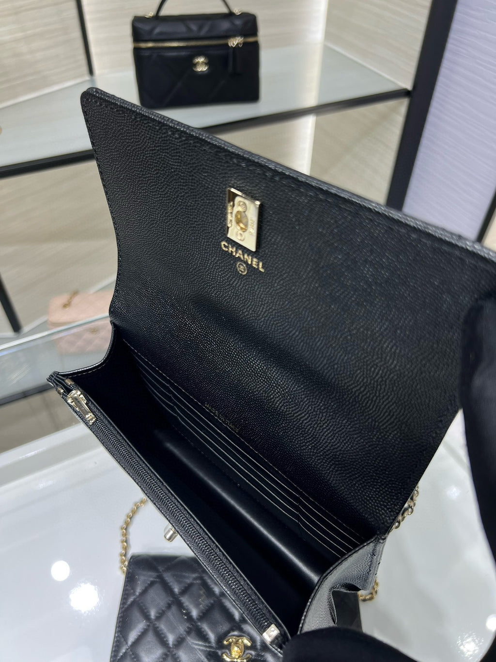 Black Chanel tote-style bag with front logo plate and long chain strap