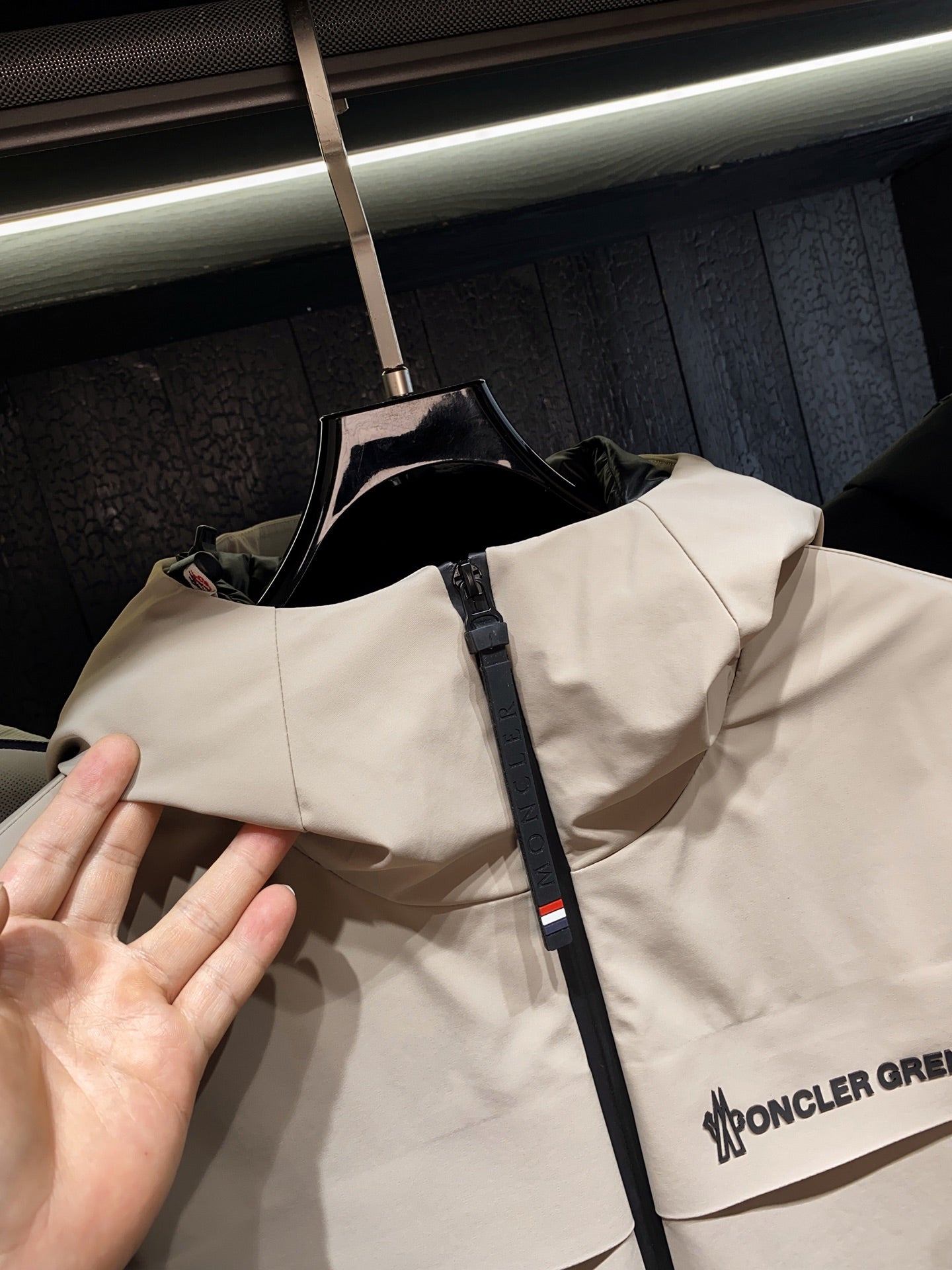 Beige hooded jacket with front zipper and logo print on chest