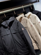 Navy and beige long parka jackets with front zippers and logo patches