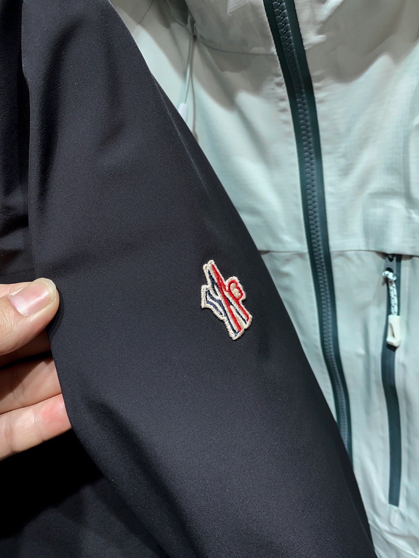 Dark parka sleeve with embroidered Moncler logo patch