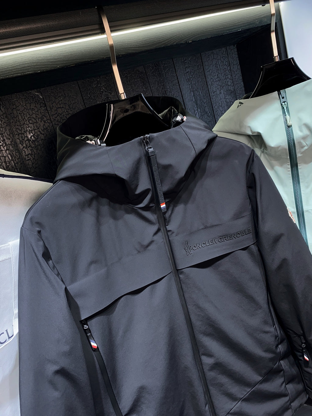 Dark long parka jacket with front zipper and chest logo detail
