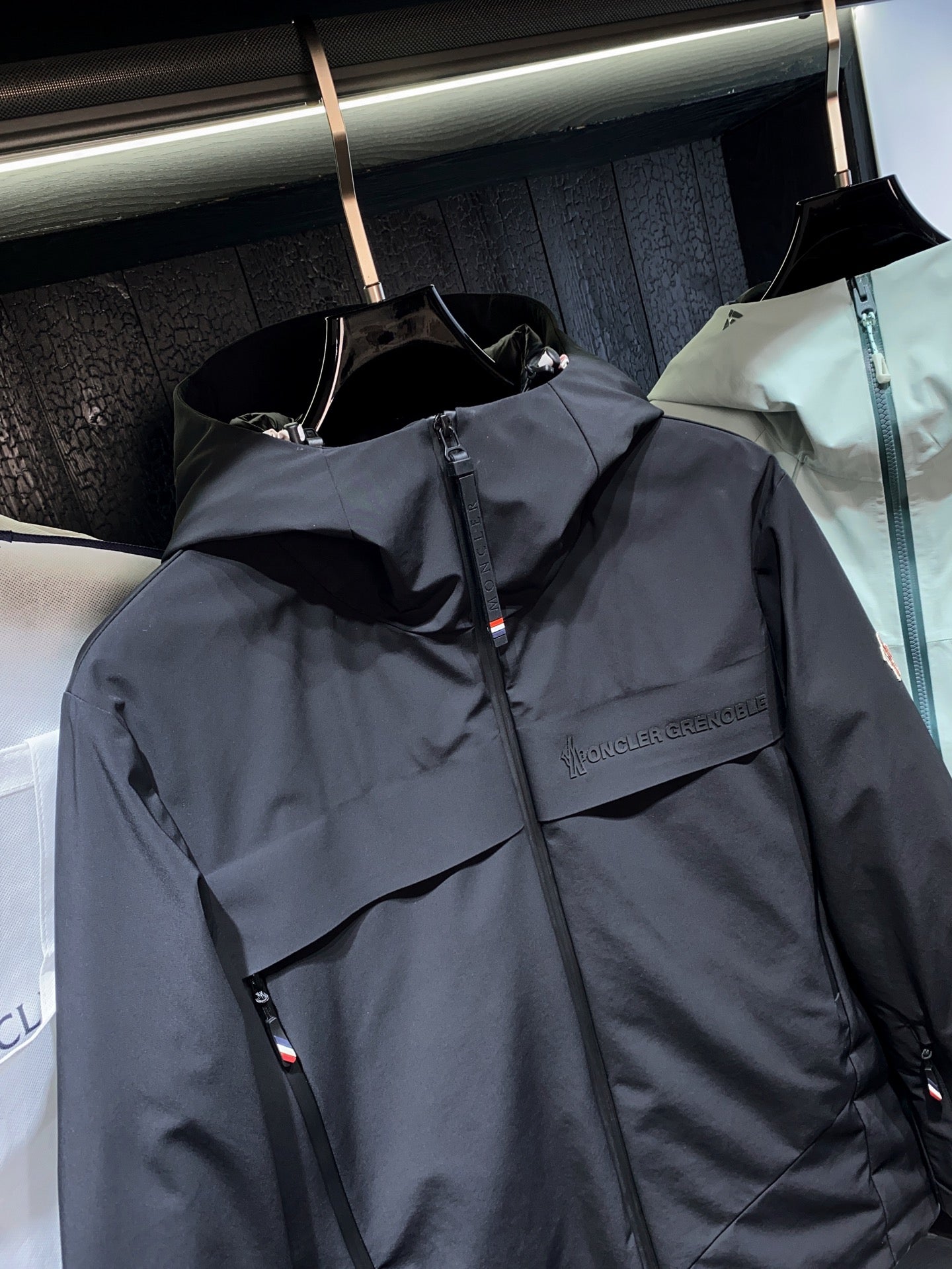 Dark long parka jacket with front zipper and chest logo detail