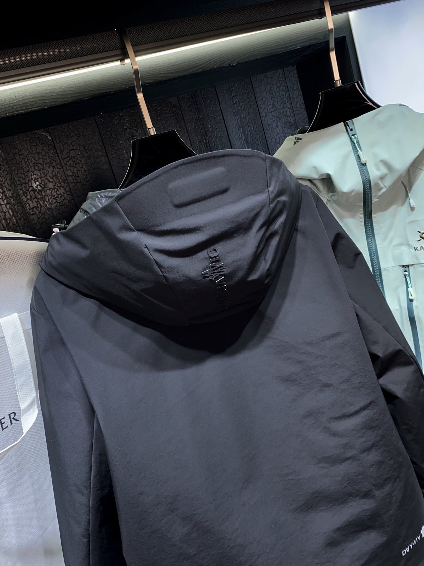 Dark long parka jacket with attached hood and back logo