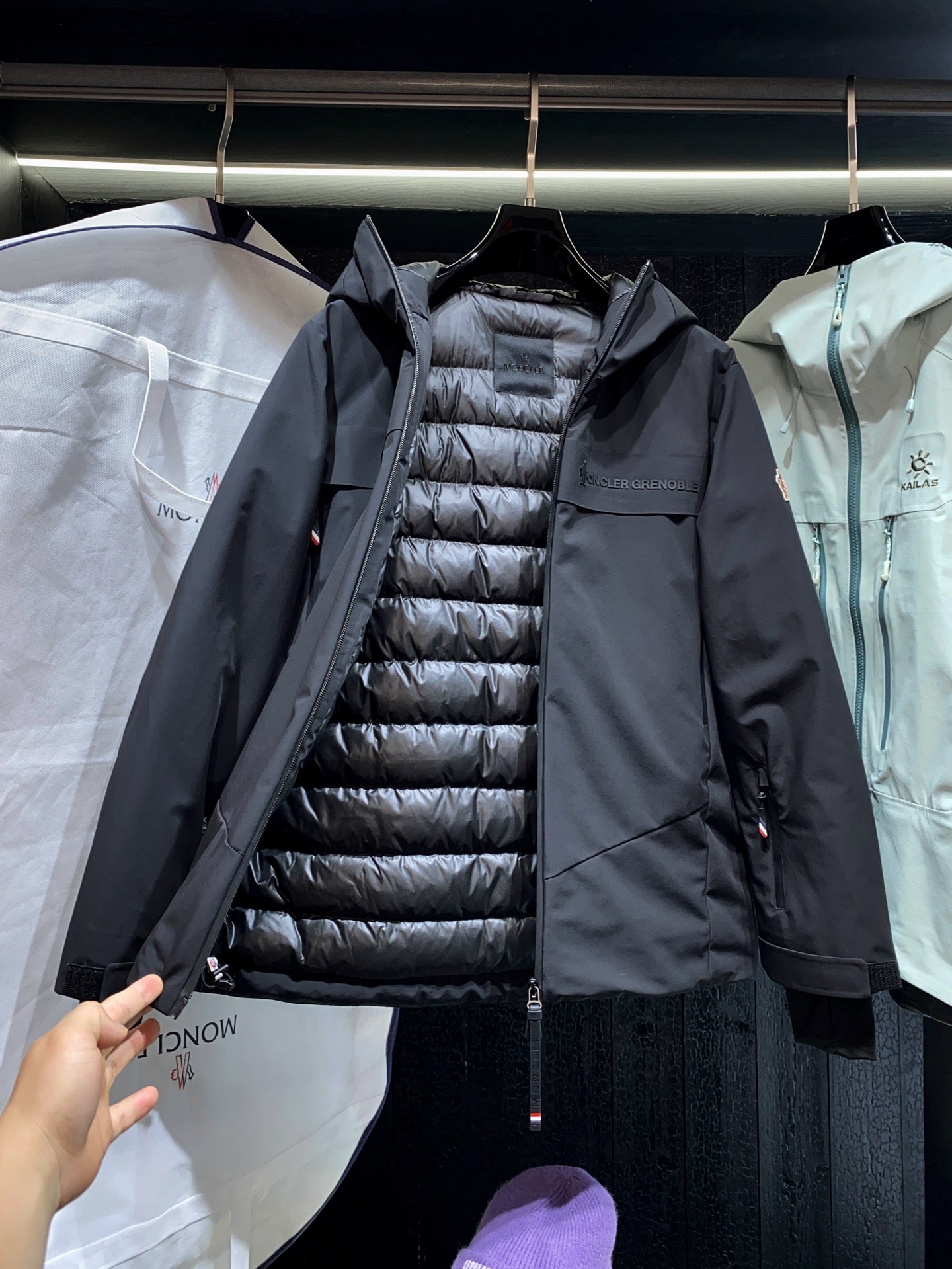 Long black parka with visible quilted inner puffer and front zipper