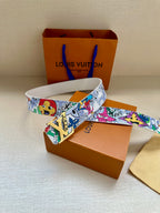 Louis Vuitton belt laid out with colorful cartoon-pattern strap and gold buckle