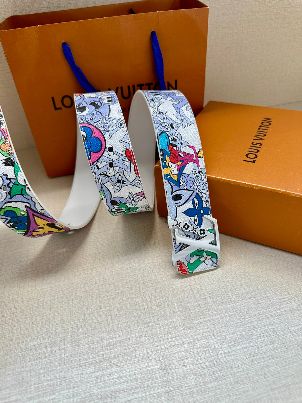 Louis Vuitton belt showing white cartoon-pattern strap and silver buckle detail