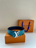 Turquoise dotted belt with gold LV buckle in front of a shopping box