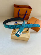 Turquoise dotted belt with gold LV buckle beside a beige dust pouch
