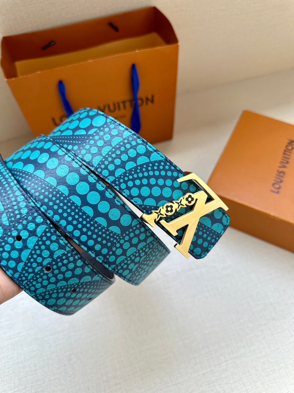 Turquoise dotted belt with gold LV buckle on a folded strap