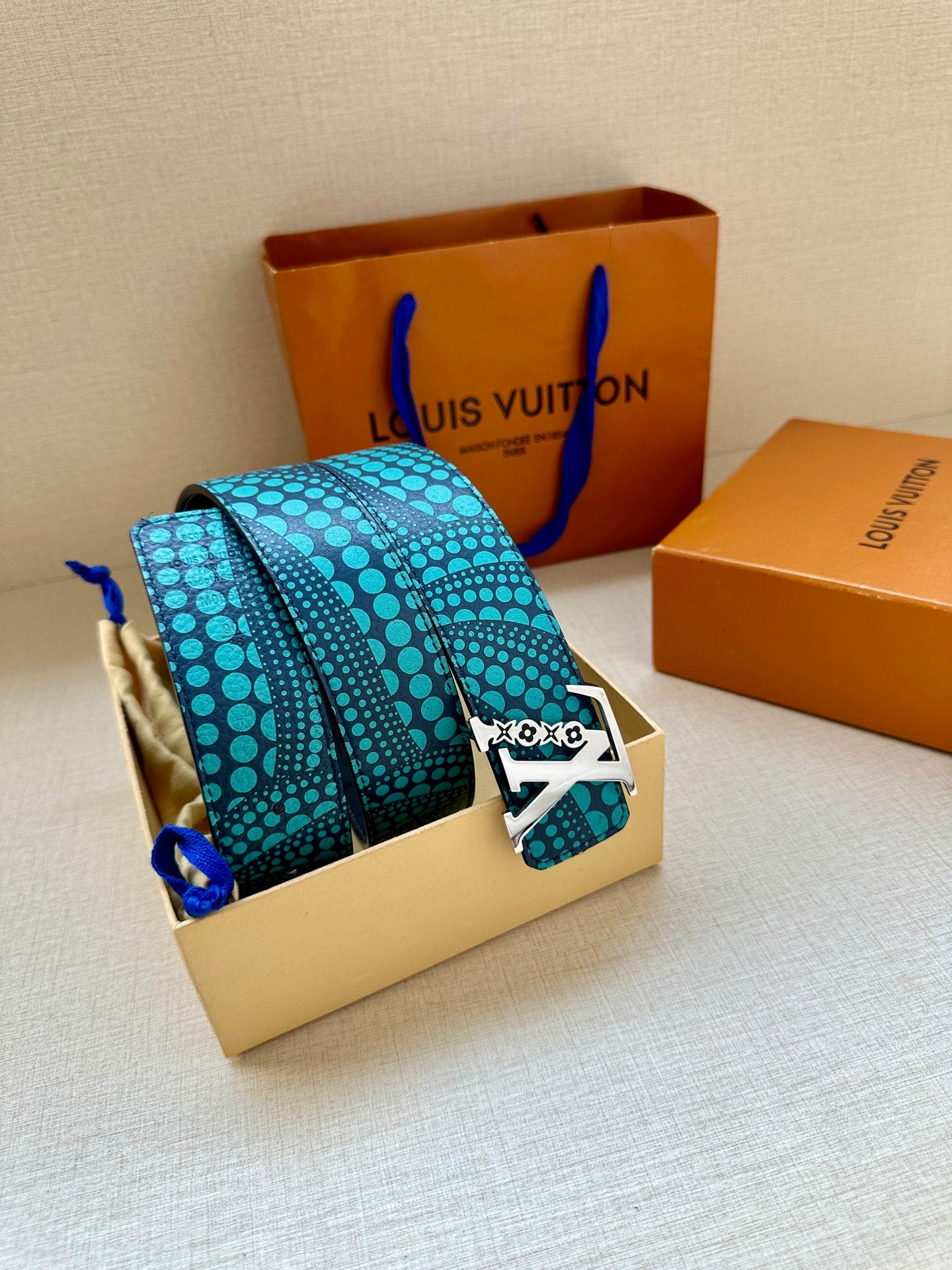 Turquoise dotted belt with gold LV buckle on a box insert