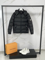 Black long puffer jacket with hood, zip front, and circular sleeve patch