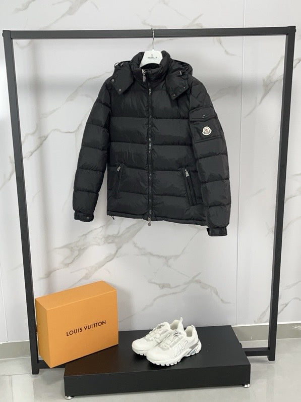 Black long puffer jacket with hooded collar and zip front, sleeve patch