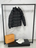 Black long puffer jacket with hood and zip front, side pocket detail